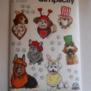 May include: A Simplicity sewing pattern for dog costumes, featuring a variety of dog breeds wearing different costumes, including a pumpkin, a bunny, a heart, a shamrock, and a red, white, and blue hat. The pattern number is S9497.