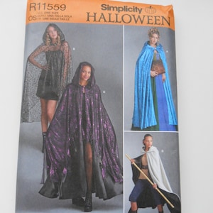 May include: Simplicity Halloween sewing pattern R11559 for making three different capes. The pattern includes instructions for a black cape with a star pattern, a purple and black cape, and a white cape. The pattern is for one size.