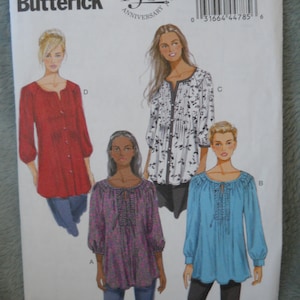May include: A Butterick sewing pattern, B5861, featuring four blouse designs. The pattern includes sizes 18W-24W. The cover displays illustrations of the blouses in red, white, floral, and blue. The pattern celebrates the 150th anniversary.