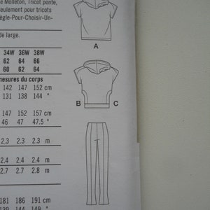 May include: A sewing pattern with instructions for making a hooded top and pants. The pattern includes measurements in inches and centimeters.