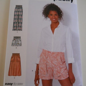 May include: A sewing pattern for women's shorts and pants. The pattern is called Simplicity S9549 and includes sizes US 6-18, Euro 32-44, and French 34-46. The pattern shows a model wearing a white shirt and pink floral shorts. The pattern also includes a diagram of the shorts and pants.
