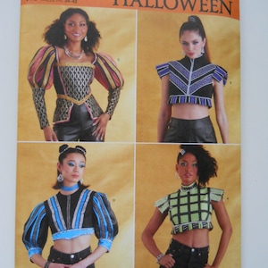 May include: Simplicity Halloween sewing pattern R11603 for sizes US 6-14, Euro 32-40, and French 34-42. The pattern includes four different crop top designs: a black and gold top with puffed sleeves, a purple and black top with a pointed collar, a black and blue top with puffed sleeves, and a green and black top with a square collar.