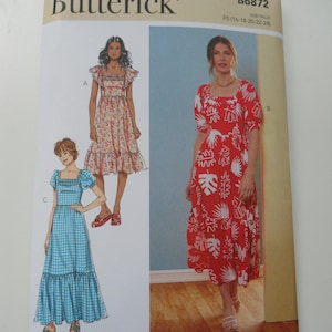 May include: Butterick sewing pattern B6872 featuring three dress designs. The pattern cover displays illustrations of the dresses, including a red floral print dress, a floral print dress, and a blue gingham dress. The pattern size is F5 (16-18-20-22-24).