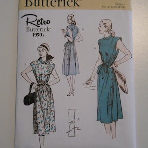 May include: Vintage sewing pattern for a dress with a retro 1950s style. The pattern includes two different styles, one with a solid blue skirt and the other with a floral print skirt. The pattern is for sizes 16-18-20-22-24.