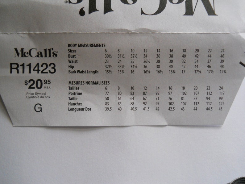 May include: A McCall's sewing pattern with the pattern number R11423 and a price of $20.95. The pattern includes body measurements in inches for sizes 6 to 24 and corresponding measurements in centimeters for French sizes 6 to 24.