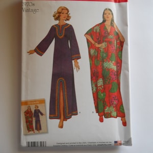 May include: Simplicity sewing pattern number 8505, vintage 1970s, for a long dress with a split in the front. The pattern includes two styles: a purple dress with a V-neck and a red and white floral dress with a V-neck.