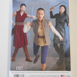 May include: Simplicity sewing pattern number 8718, size US 14-22, size Euro 40-46, size FR 42-50. The pattern includes three different outfits: a red dress with a belt, a brown vest with a beige shirt and blue pants, and a black jacket with a black skirt and black pants.