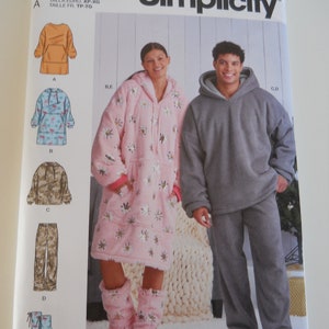 May include: Simplicity sewing pattern number 59456 for a hooded sweatshirt and pants. The pattern includes a variety of styles, including a long, oversized hooded sweatshirt with a pocket, a shorter hooded sweatshirt with a print, a pair of pants, and a pair of boot covers.