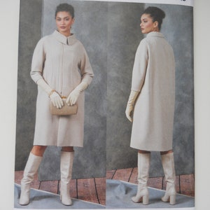 May include: Vogue Patterns sewing pattern for a long, white coat with a collar and long sleeves. The pattern is designed by Guy Laroche and is for sizes X-Small, Small, and Medium.