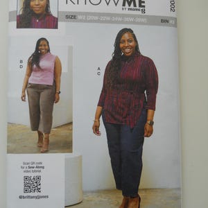 May include: Know Me by Mimi G sewing pattern for a top and pants. The pattern is for sizes 20W-28W. The pattern cover features a model wearing a burgundy top with a tie waist and black pants. A second model is wearing a pink top and khaki pants.