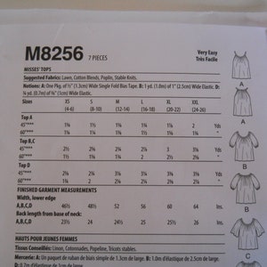 May include: A sewing pattern for tops, labeled M8256, with instructions for sizes XS to XXL. The pattern includes seven pieces and is rated as very easy to sew. The pattern includes a table with measurements for different sizes and types of tops.