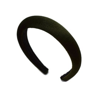May include: A dark green velvet headband. The headband is wide and has a simple design.