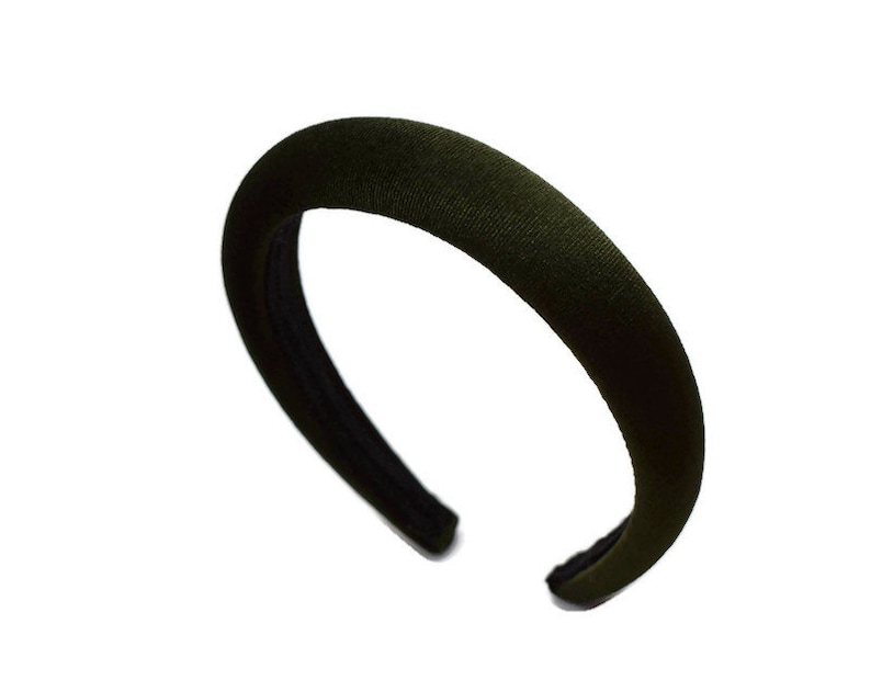 May include: A dark green velvet headband. The headband is wide and has a simple design.