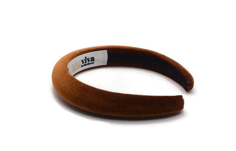 May include: A brown velvet headband with a white label that says "viva la difference".
