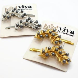 Laurel Clip Range - Zestaw 2 spinek do włosów w kolorze złotym i srebrnym o długości 65 mm, wysokiej jakości, zdobionych liśćmi i perłowymi detalami, piękny prezent dla niej