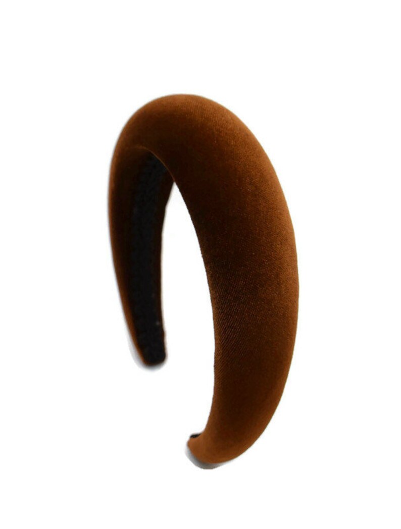 May include: A brown velvet headband with a wide, curved shape.