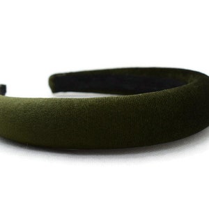 May include: A wide, dark green velvet headband. The headband is thick and has a smooth, soft texture.