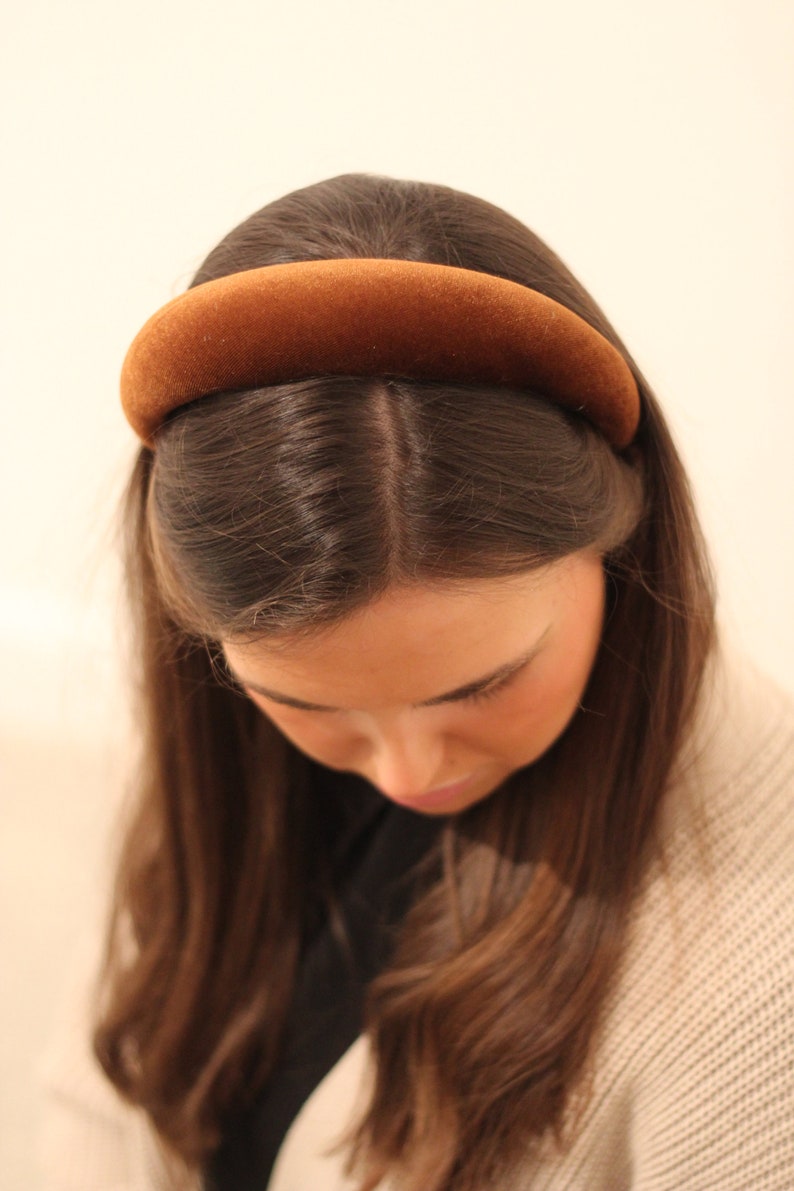 May include: A brown velvet headband for women. The headband is wide and has a simple, elegant design.
