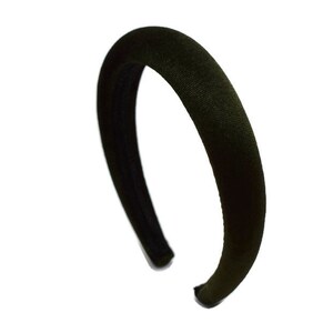 May include: A black velvet headband. The headband is wide and has a smooth, soft texture.