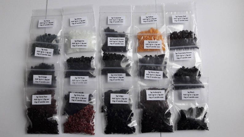May include: A collection of 16 small plastic bags containing various colored wax flakes. Each bag has a label with the name of the color and instructions for adding the flakes to candle wax. The colors include: Jade, Orange, Cherry Red, Dirty Pink, Magenta, Emerald Green, Lime Green,  Wisteria Red,  Lavender,  Chocolate Brown,  Black,  and  Rubine.