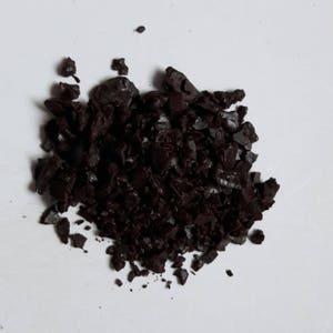 May include: A pile of dark brown coffee grounds.