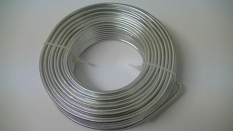Op de afbeelding: Een rol zilverkleurige aluminiumdraad, opgerold en vastgebonden met witte plastic tie-wraps.