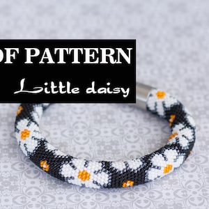 Pode incluir: Padrão PDF para uma pulseira de contas com um design de margarida preto e branco. A pulseira é feita com contas pequenas e tem um fecho prateado.