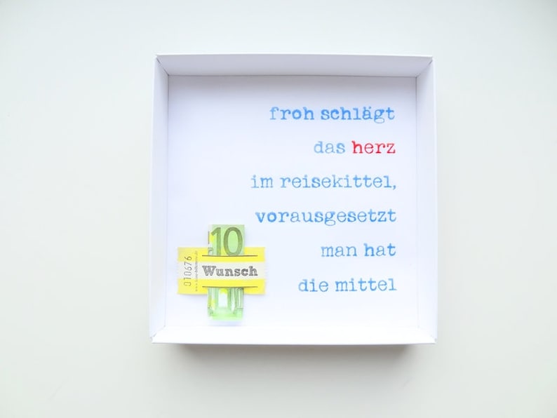 May include: A white frame with a white background and blue and red text that reads "froh schl&auml;gt das herz im reisekittel, vorausgesetzt man hat die mittel". A yellow sticker with the word "Wunsch" and the number "10" is attached to the frame.