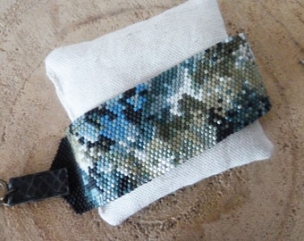 Woven cuff bracelet in green and blue tones with nebula pattern, camouflage style