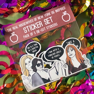 Könnte beinhalten: Ein Set mit fünf ausgestanzten Aufklebern mit Figuren aus den Real Housewives of New York City. Die Aufkleber sind auf weißem Papier mit schwarzen Umrissen gedruckt und zeigen Zitate aus der Show. Die Aufkleber sind in einer durchsichtigen Plastiktüte mit einem roten und weißen Etikett verpackt, auf dem "The Real Housewives of New York OG Inspired Sticker Set" steht.