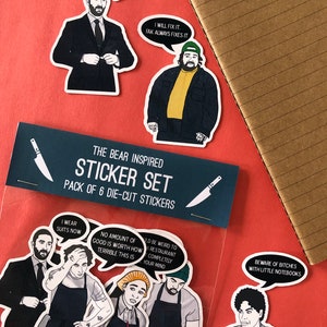 K&ouml;nnte beinhalten: Ein Set mit sechs gestanzten Aufklebern mit Figuren und Zitaten aus der TV-Serie "The Bear". Die Aufkleber sind auf wei&szlig;em Papier gedruckt und haben eine gl&auml;nzende Oberfl&auml;che. Die Aufkleber enthalten Zitate wie "Ich trage jetzt Anz&uuml;ge", "Keine Menge an Gutem ist es wert, wie schrecklich das ist", "Ich werde es reparieren. Fak repariert es immer", und "Vorsicht vor H&uuml;ndinnen mit kleinen Notizb&uuml;chern".
