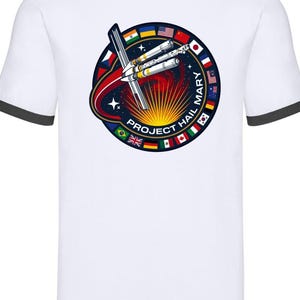 Op de afbeelding: Een wit ringer-t-shirt met een zwarte kraag en mouwboorden. Het midden toont een cirkelvormige afbeelding met een ruimtestation, een heldergele zonnestraal en internationale vlaggen, met de tekst PROJECT HAIL MARY.