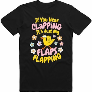 May include: Black t-shirt featuring the text "If You Hear CLAPPING It's Just My FLAPS FLAPPING" in pink and yellow. A yellow cartoon bird with orange legs and a blue eye is surrounded by flowers.
