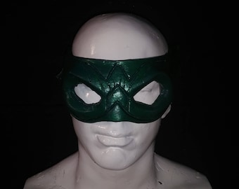Può includere: Una maschera per gli occhi verde con un design in rilievo. La maschera è in pelle e ha uno stile semplice e classico.