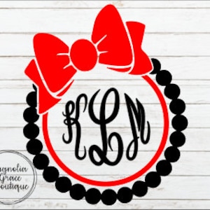 May include: A red bow tops a black beaded circle with a red inner circle. The initials "KLM" are in the center in a black script font. The logo for "Magnolia Grace Boutique" is in the lower left corner.