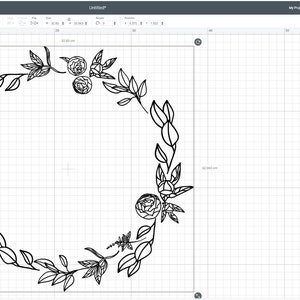 Puede incluir: Un dise&ntilde;o de corona floral en blanco y negro. La corona est&aacute; compuesta por hojas y flores, con forma circular. El dise&ntilde;o se muestra sobre un fondo de cuadr&iacute;cula, lo que sugiere un proyecto de arte o artesan&iacute;a digital.