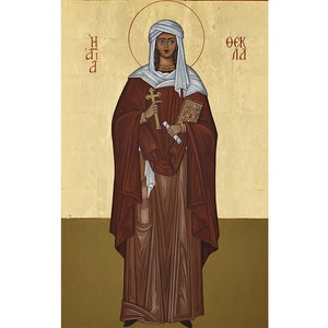 May include: An icon depicting a woman in a brown robe and white head covering, holding a cross and a scroll. The background is a light yellow with gold accents. The text "Η ΑΓΙΑ" is on the left and "ΘΕΚΛΑ" is on the right.
