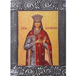 May include: Icon of a woman in a crown and red robe, holding a cross. The icon has gold and red tones, with text in the upper corners. The frame is silver with an ornate design.