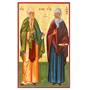 Puede incluir: Una pintura de icono de dos figuras, un hombre y una mujer, de pie uno al lado del otro. El hombre lleva una túnica verde y un turbante blanco. La mujer lleva una túnica azul y una cubierta de cabeza blanca. Ambas figuras sostienen rollos en sus manos. El fondo es de color verde y dorado.