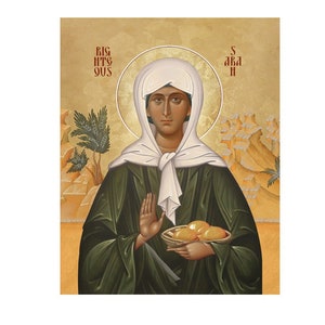 Peut inclure: Icône représentant une femme vêtue d'un voile blanc et d'une robe verte, tenant un panier de pain. Le fond est doré avec du texte rouge. La femme a un halo autour de la tête.