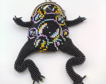 May include: A black beaded frog coin purse with a colorful floral design and a brass clasp.