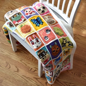 May include: A colorful crocheted blanket with a square pattern featuring various animal characters. The blanket is made with different shades of brown, orange, yellow, green, blue, purple, and white yarn.