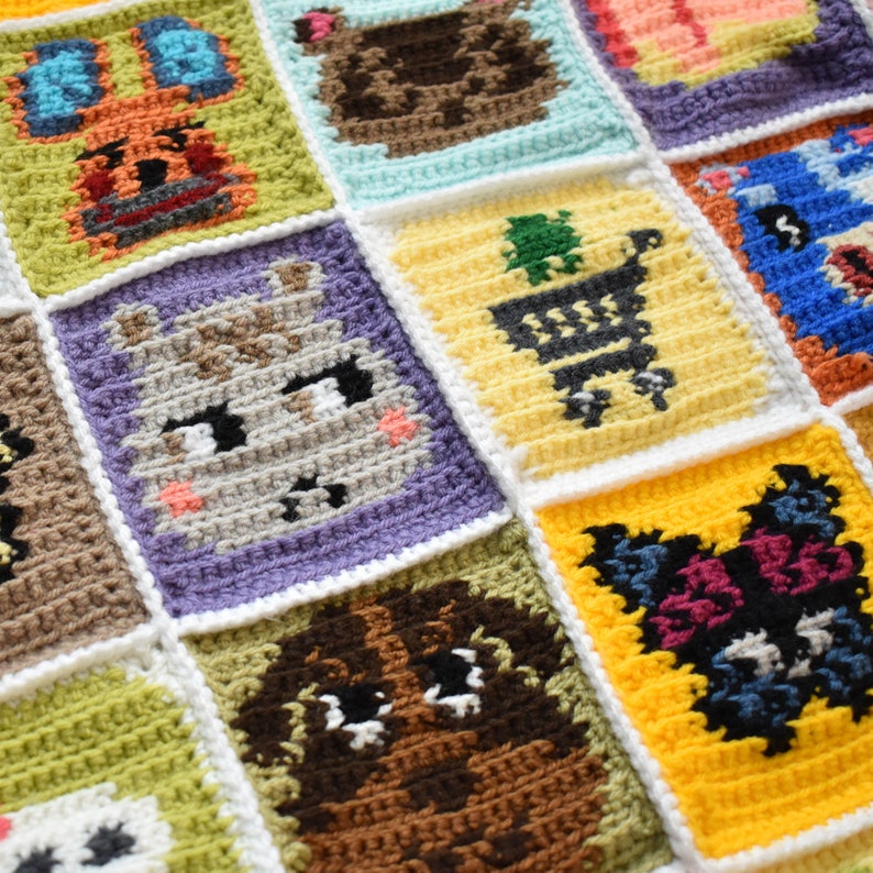 May include: A crocheted blanket with a variety of colorful squares featuring animal characters. Each square is outlined in white and features a different animal, including a bunny, a bear, a deer, a cat, and a dog.
