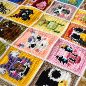 May include: A crocheted blanket made of colorful squares with different animal designs. Each square features a different animal, including a cow, a pig, a sheep, and a dog. The blanket is made with a variety of colors, including pink, yellow, blue, green, and brown.