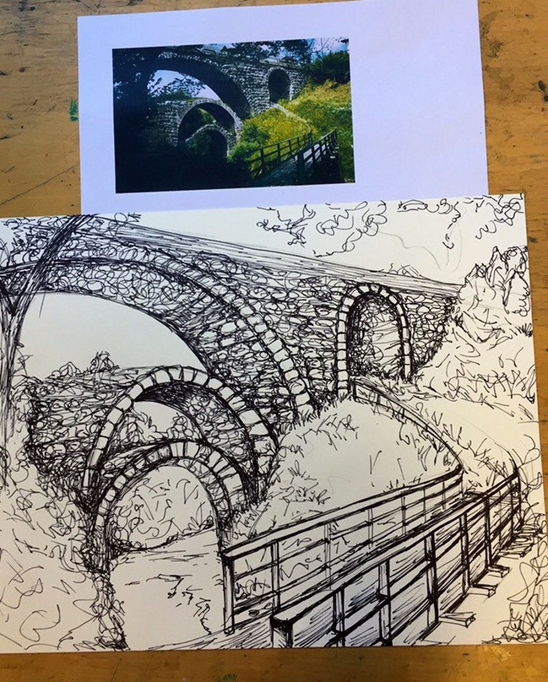 Puede incluir: Un dibujo en tinta negra y blanca de un puente de piedra con m&uacute;ltiples arcos. El puente est&aacute; rodeado de &aacute;rboles y arbustos. Una pasarela de madera con barandilla conduce al puente.