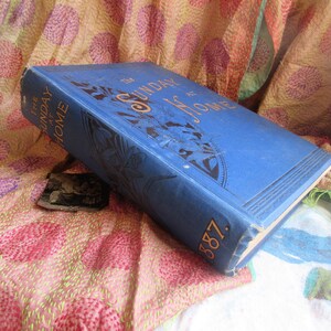May include: A blue book with gold lettering that reads 'The Sunday at Home 1887'.
