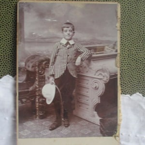 young Victorian boy with exceptional sporting costume, cabinet photo, wearing stiped blazer, pith helmet, incredibly happy /proud boy, rare