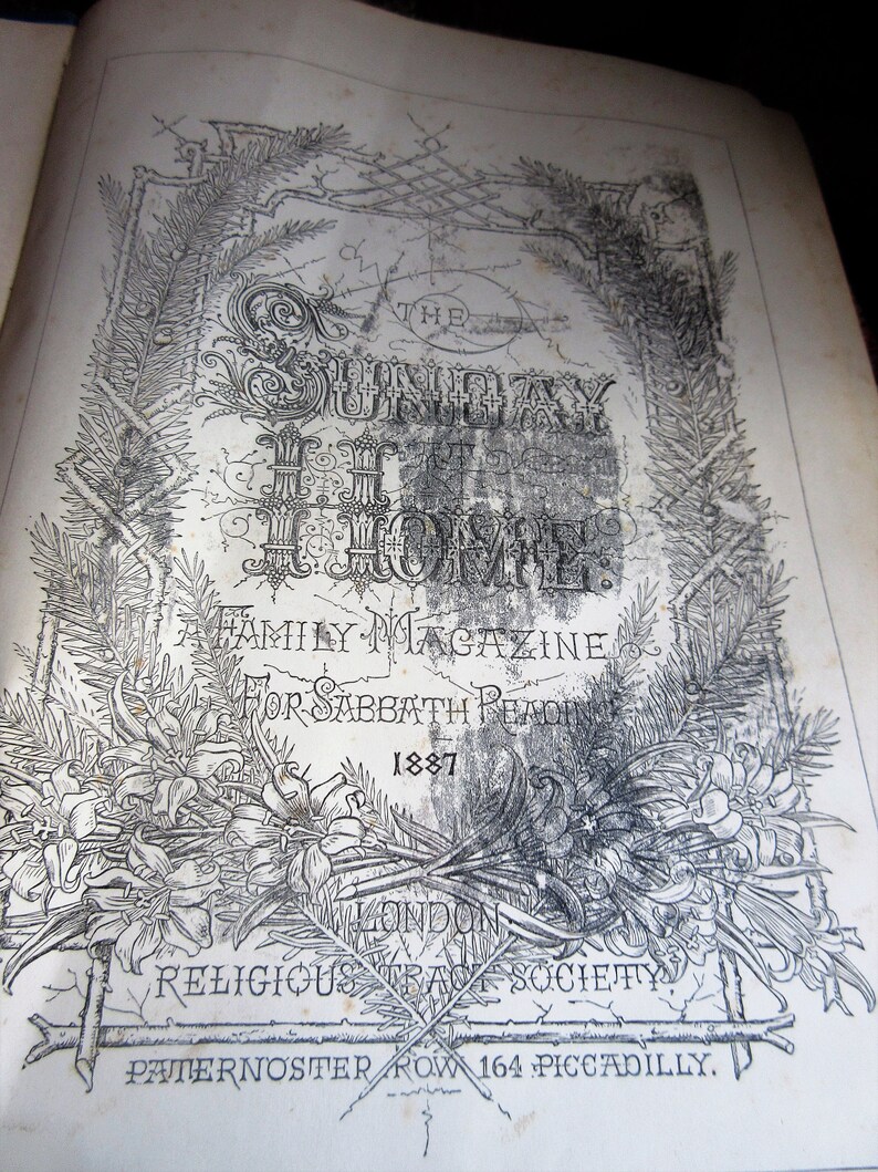 May include: A black and white image of a book cover for a magazine called 'Sunday at Home.' The cover features a decorative border of floral and leaf designs. The title is in large, bold letters and the subtitle is 'Family Magazine for Sabbath Reading.' The year 1887 is printed below the subtitle. The publisher information is printed at the bottom of the cover: 'London, Religious Tract Society, Paternoster Row 164 Piccadilly.'