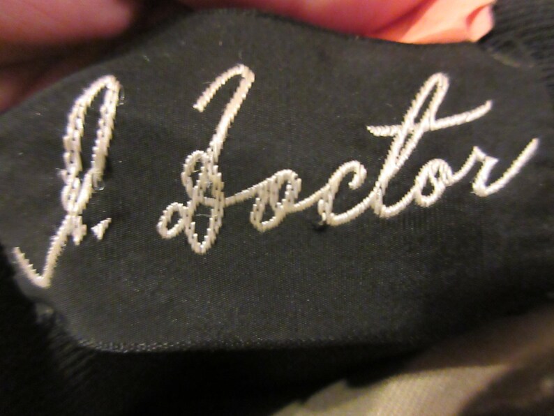 May include: A black fabric patch with white embroidery that reads "J. Factor".