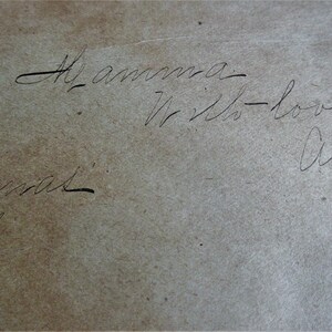 May include: A handwritten note on a light brown paper surface. The note reads 'To amma - With love - Alice - Christmas 1887.'
